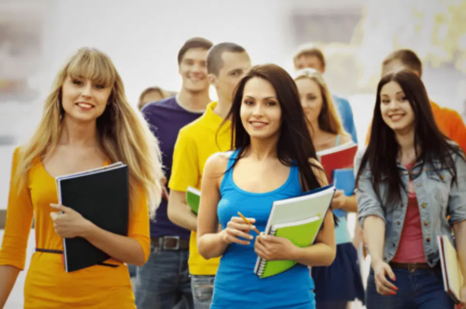 Group of smiling students holding books